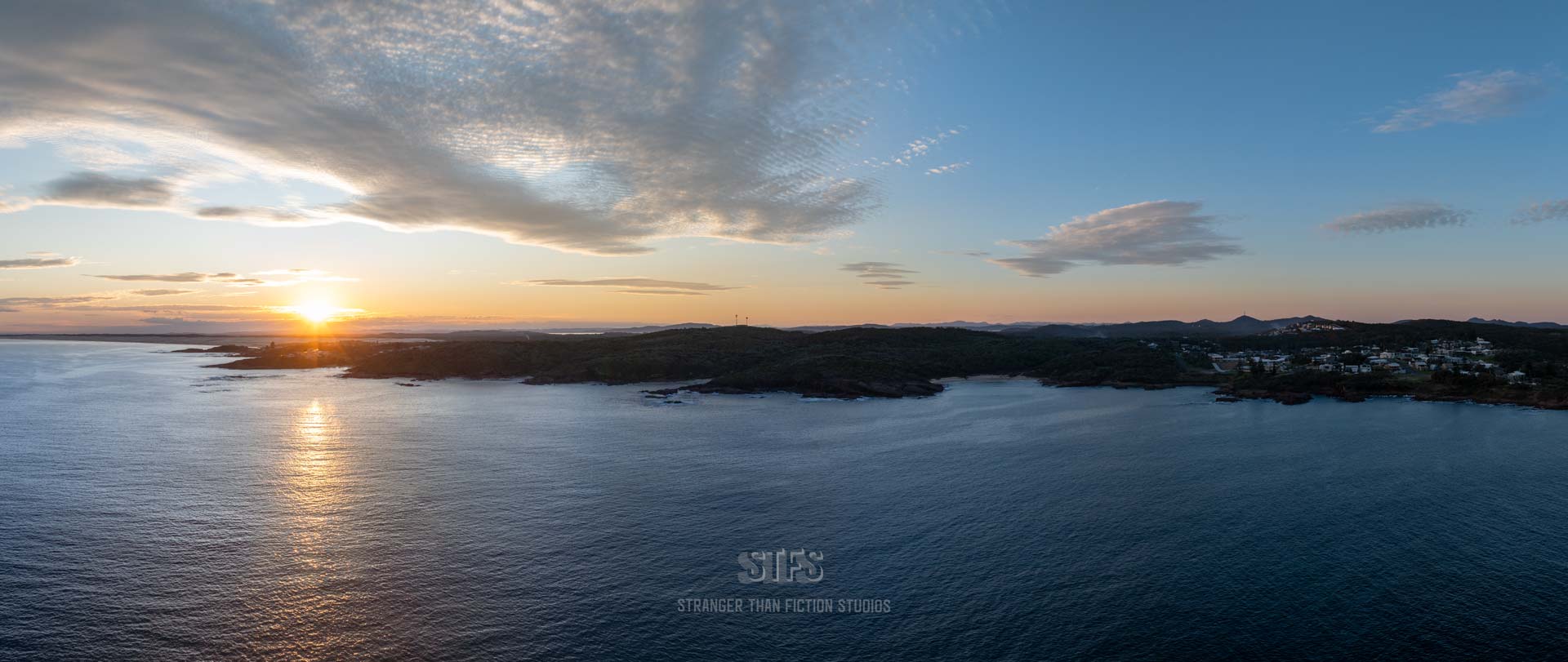 Panoramic Drone Image Of The Port Stephens Coastline From Boat Harbour To The Birubi Point Surf Club. Captured At Sunset With Golden Sky Above And Sand Dunes Behind.